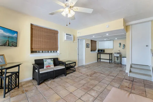 a view of a house with potted plants and a bench