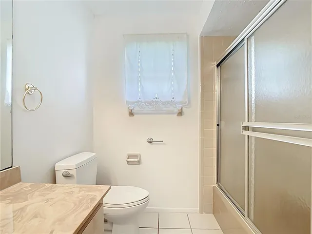a bathroom with a granite countertop toilet and a shower