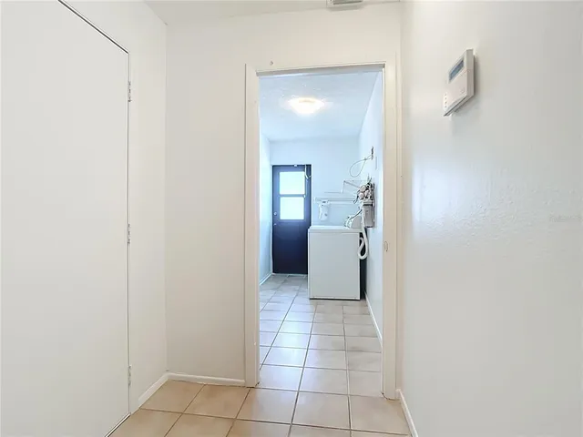 a view of a hallway with a bathroom and mirror