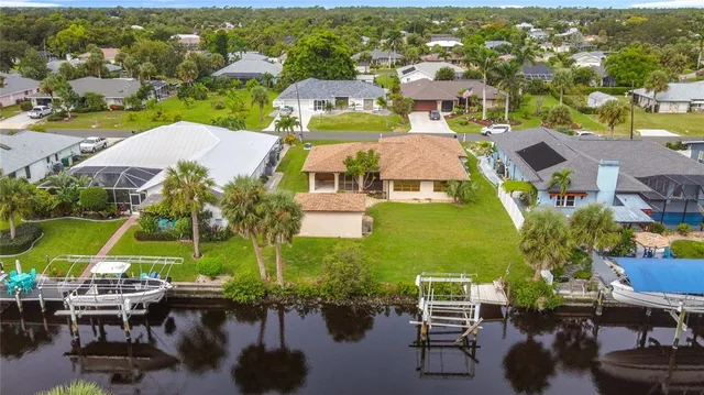 an aerial view of residential houses with outdoor space and lake view