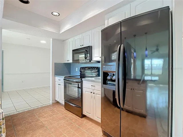 a kitchen with stainless steel appliances granite countertop a refrigerator a stove and a sink