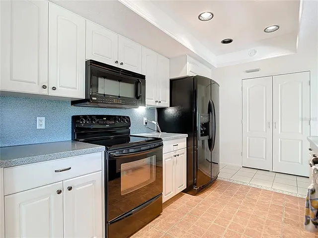 a kitchen with stainless steel appliances granite countertop a stove a microwave and a refrigerator