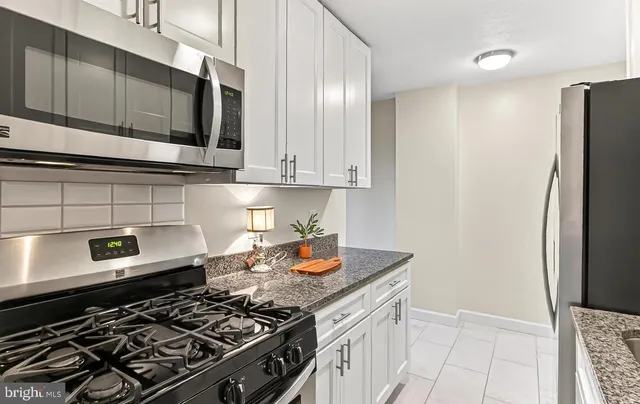 a kitchen with stainless steel appliances granite countertop a stove and a refrigerator