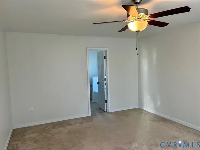 an empty room with a chandelier fan and a ceiling fan