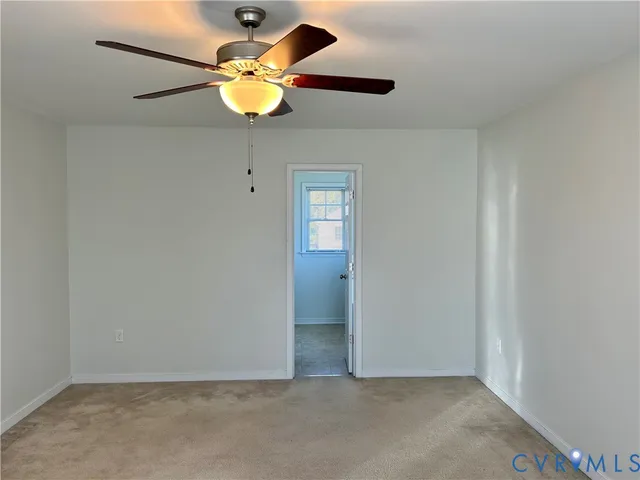 an empty room with closet and chandelier fan