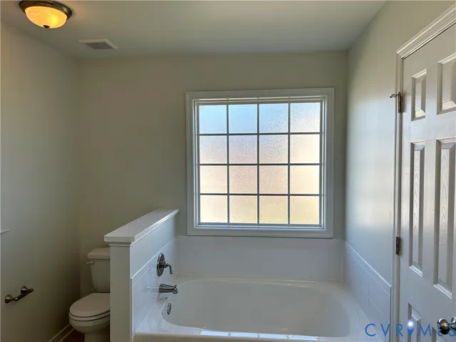 a white bath tub sitting next to a white toilet