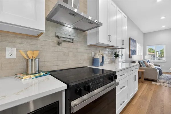 a kitchen with a stove a sink and cabinets