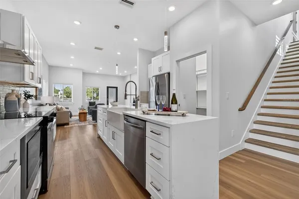 a kitchen with stainless steel appliances a sink stove and cabinets