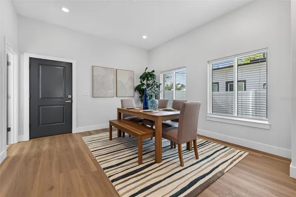 a living room with furniture a dining table and a window