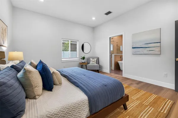 a bedroom with a bed and wooden floor