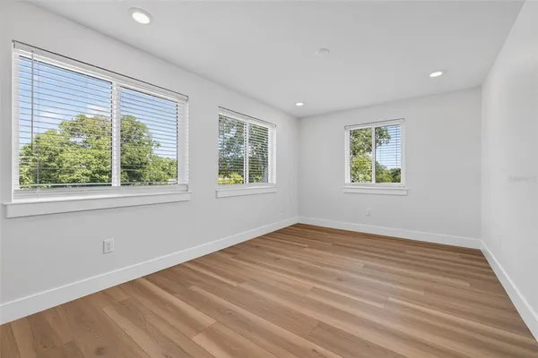 a bathroom with a toilet a sink a mirror a window and vanity