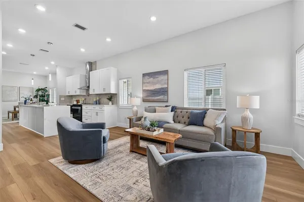 a living room with furniture and a view of kitchen