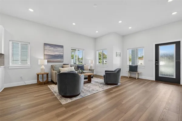 a living room with furniture wooden floor and windows