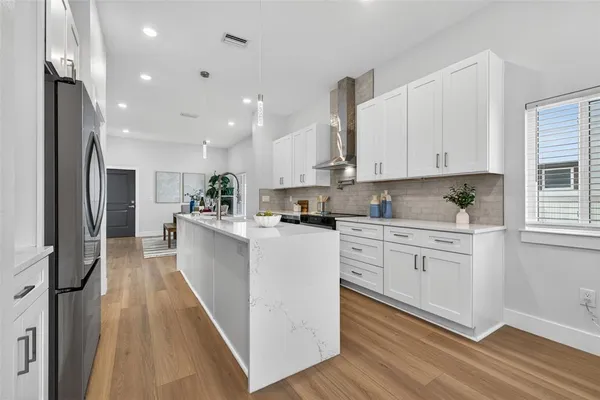 a kitchen with white cabinets and stainless steel appliances