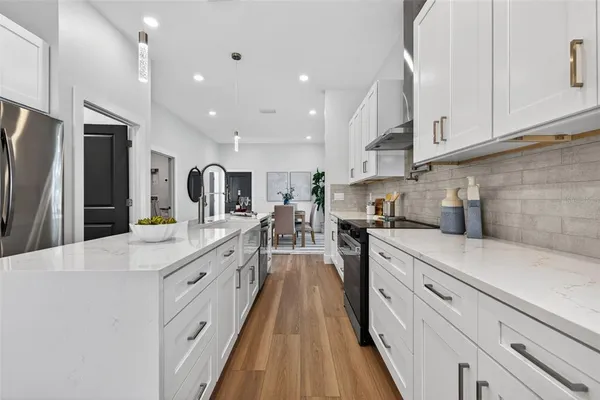 a large kitchen with stainless steel appliances lots of counter space and wooden floor