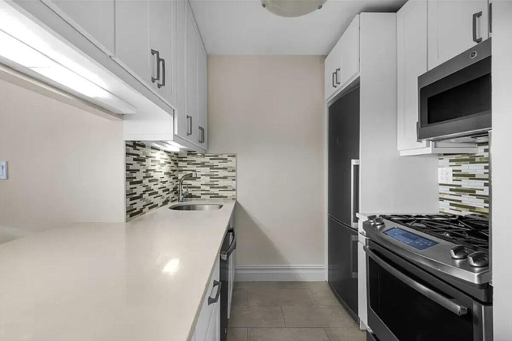 204 Rector Place, Unit 10L Manhattan, NY 10280 - Photo 5 of 10 a kitchen with a stove and a microwave