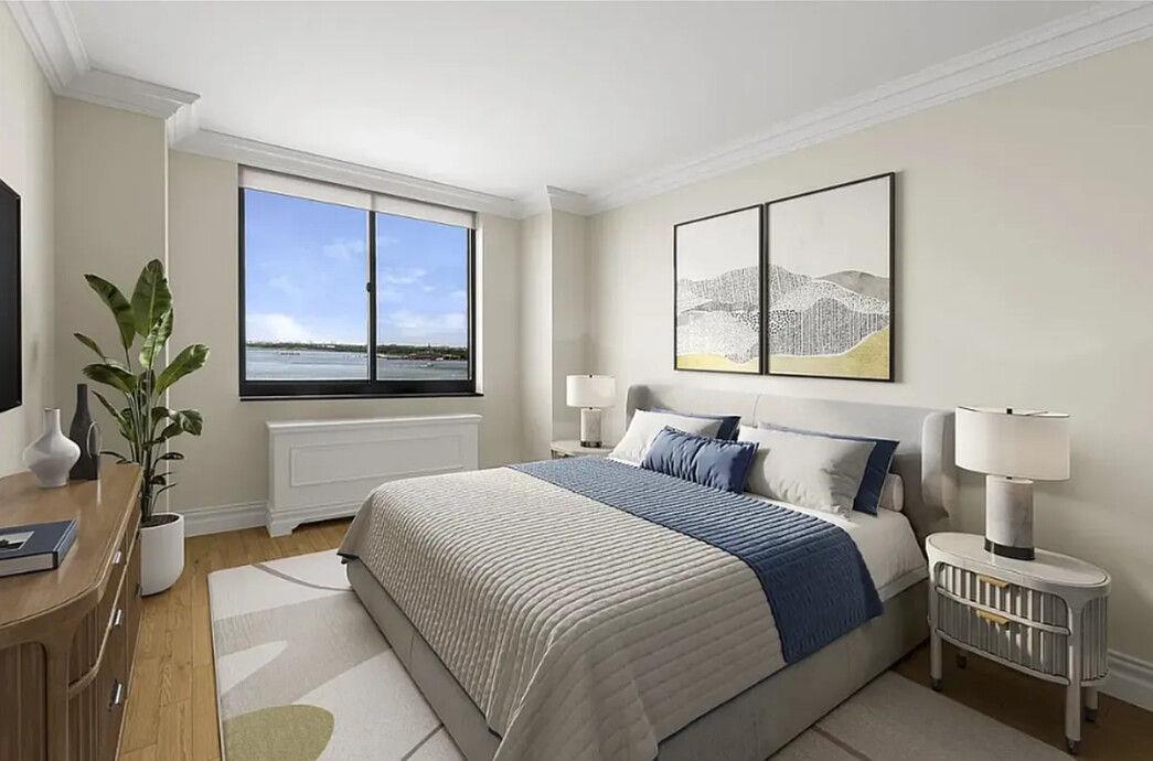 204 Rector Place, Unit 10L Manhattan, NY 10280 - Photo 6 of 10 a bedroom with a large bed and a potted plant