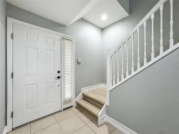 a view of a hallway with staircase and white walls