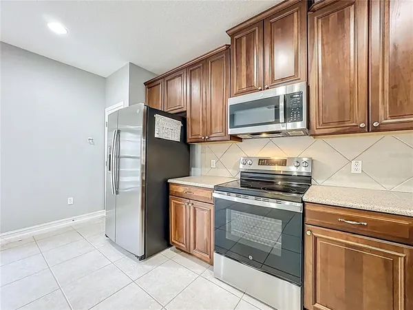 a kitchen with granite countertop wooden cabinets and stainless steel appliances