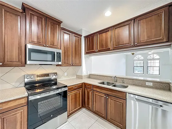 a kitchen with granite countertop cabinets stainless steel appliances and a sink
