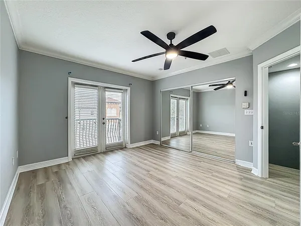 an empty room with wooden floor and windows