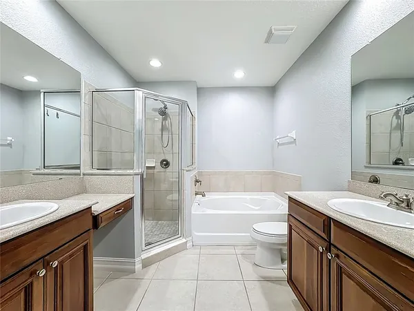 a bathroom with a bathtub shower sink mirror vanity and toilet