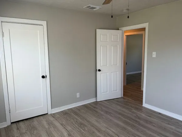 an empty room with wooden floor and a window
