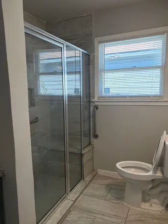 a bathroom with a toilet and a shower