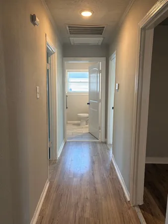 a view of a hallway with wooden floor