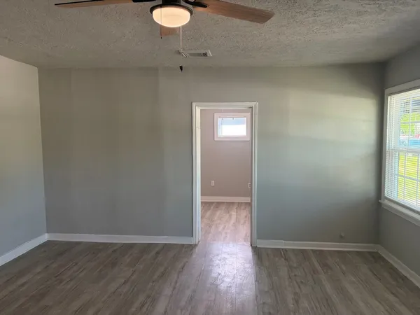 wooden floor in an empty room with a window