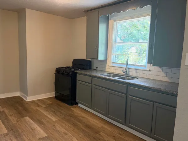 a kitchen with a sink cabinets and a window