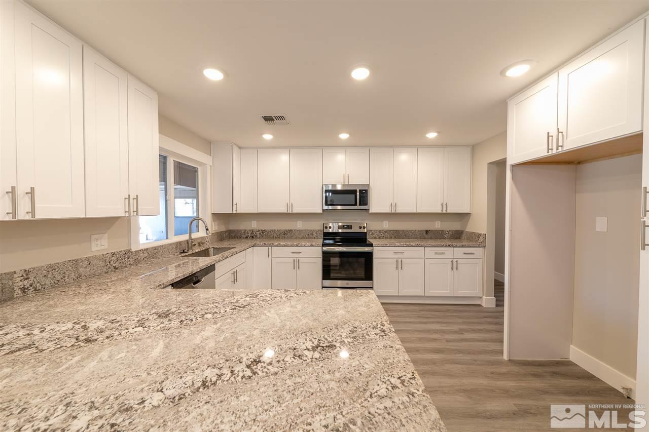 1070 Foothill Road Reno, NV 89511 - Photo 5 of 17 a kitchen with granite countertop a refrigerator and a sink