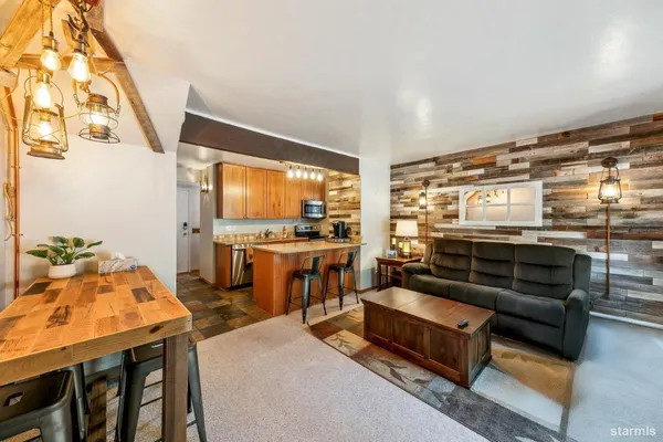 a living room with stainless steel appliances kitchen island granite countertop furniture and a large window
