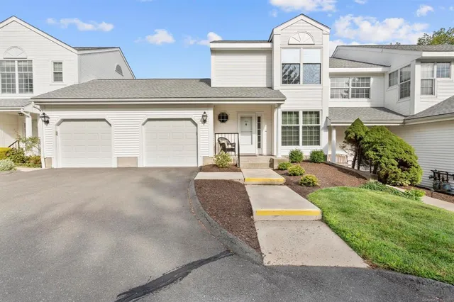 a front view of a house with a yard and potted plants