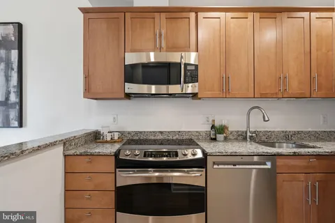a kitchen with granite countertop cabinets stainless steel appliances and a sink