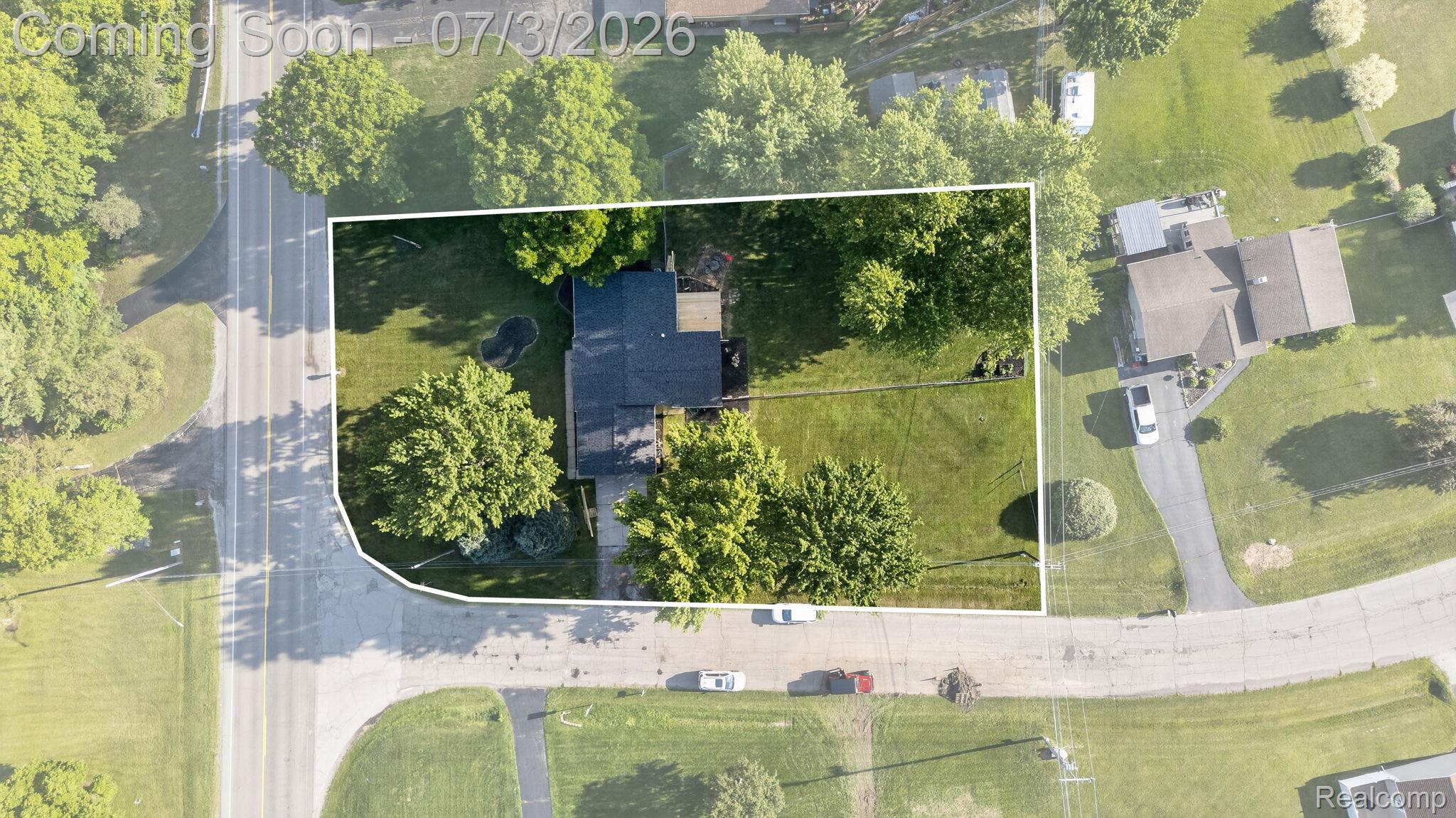 5355 North Seymour Road Flushing, MI 48433 - Photo 40 of 41 Aerial view showcasing a residential property with a dark-roofed structure, featuring a substantial grassy yard and mature trees