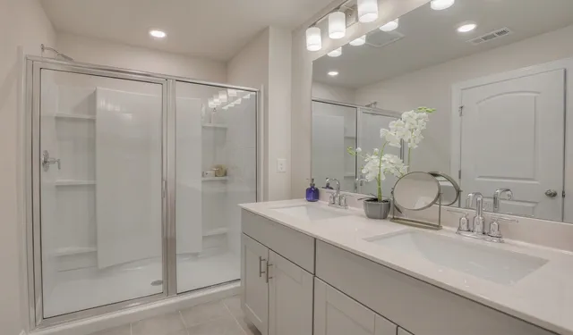 a bedroom with a bed and a lamp on dresser