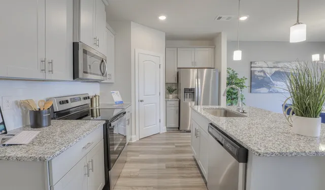 a kitchen with sink a microwave and cabinets