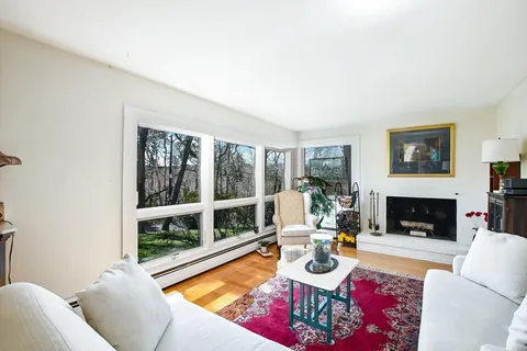 a living room with furniture large window and a fireplace