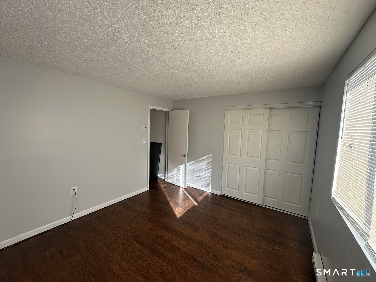 39 Horton Hill Road, Unit 7C Naugatuck, CT 06770 - Photo 12 of 29 an empty room with wooden floor and windows