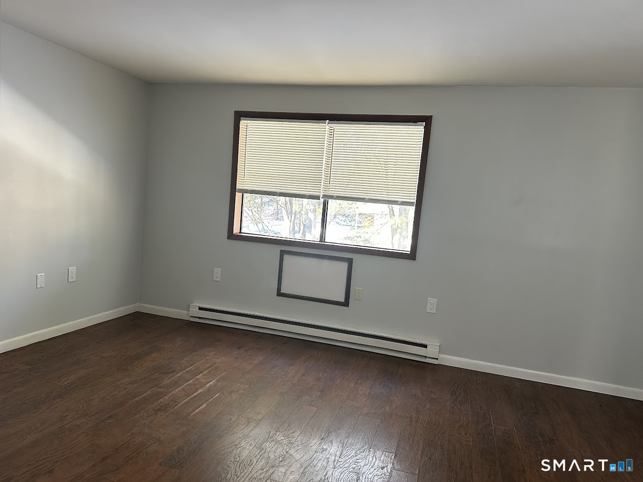 39 Horton Hill Road, Unit 7C Naugatuck, CT 06770 - Photo 23 of 29 an empty room with wooden floor and windows