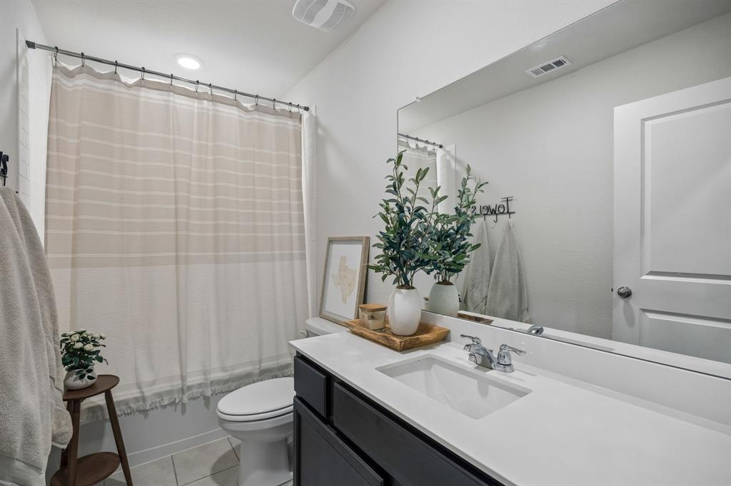 1107 Ringgold Road Forney, TX 75126 - Photo 21 of 27 Secondary Bathroom featuring a dark wood-finish vanity with a white solid surface countertop, an integrated rectangular sink, and a large wall-mounted mirror