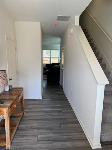 a view of a hallway with wooden floor and staircase