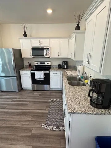 a kitchen with granite countertop a stove and cabinets