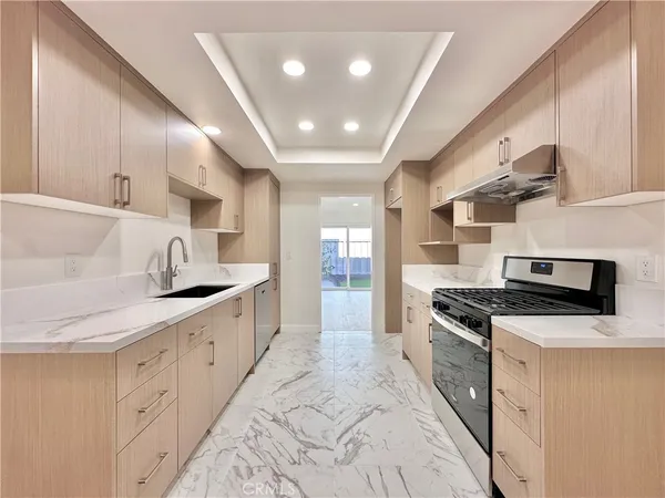 a kitchen with granite countertop a sink stainless steel appliances and cabinets