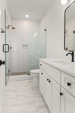 a bathroom with a sink a toilet and shower