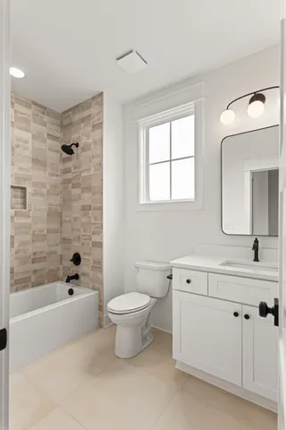a bathroom with a toilet a sink a mirror a bathtub and vanity