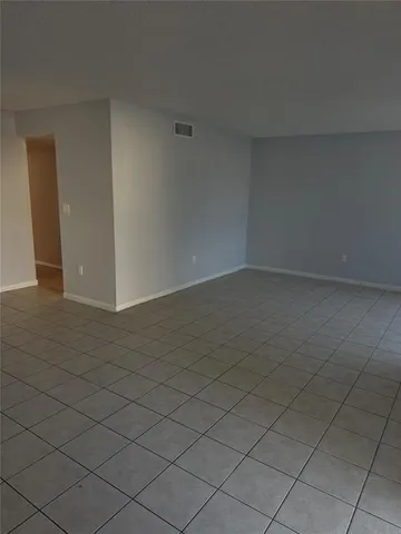 a view of a livingroom with an empty space and a window