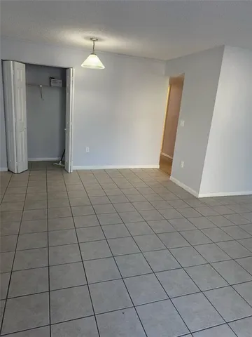 an empty room with wooden floor cabinet and windows