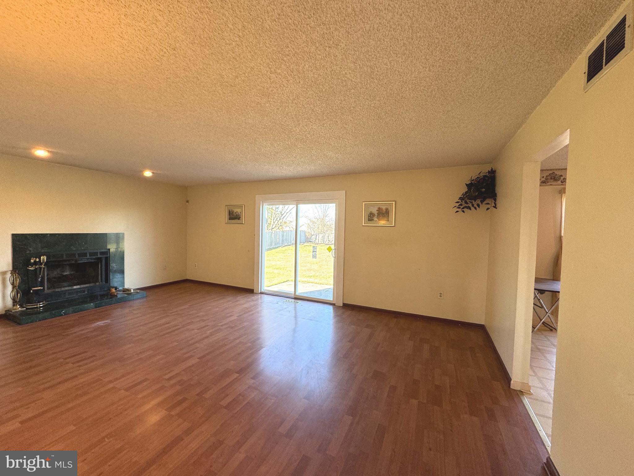 2530 Klockner Road Hamilton, NJ 08690 - Photo 4 of 16 a view of empty room with wooden floor and fireplace
